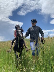 Harley and his rider on a trail ride during an adaptive riding class.