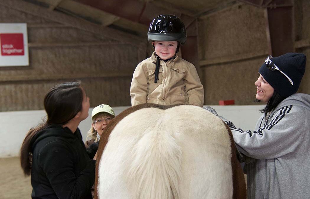 A young rider smiles while riding backwards